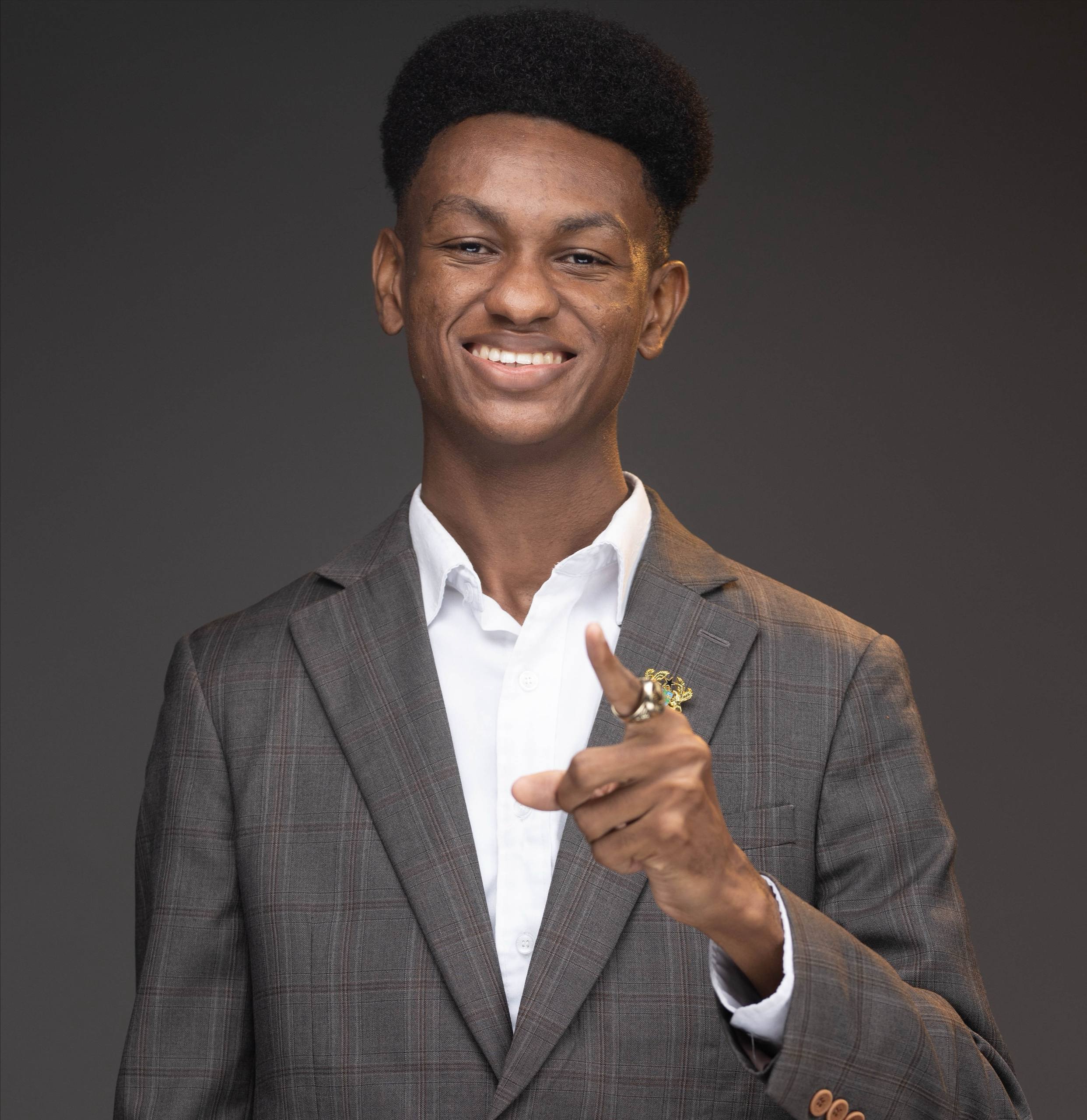 A confident African leader in a tailored suit, smiling and pointing toward the viewer